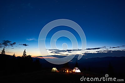 Family hikers having a rest at night camping in mountains Stock Photo