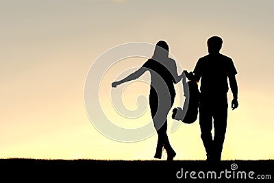 Silhouette of Family of Three People Walking at Sunset Stock Photo