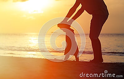 Silhouette of father and daughter learning to walk Stock Photo