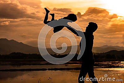 Silhouette Father throwing his kid up in the air Stock Photo