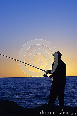 Silhouette of Fisherman Stock Photo