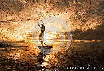 Silhouette Fisherman Fishing Nets on the boat. Stock Photo
