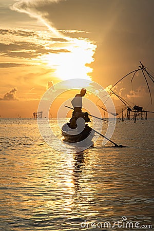 Silhouette of fisherman on his boat at sunrise in the morning Stock Photo