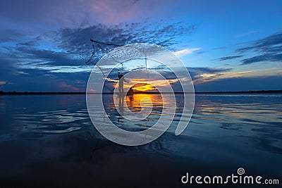 Silhouette fisherman with net at the lake Stock Photo