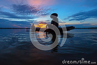 Silhouette fisherman with net at the lake Stock Photo