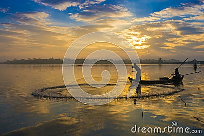 The silhouette of Fisherman throwing net in the early morning near U Bein Bridge, , Taungthaman Lake near Amarapura, Myanma Editorial Stock Photo