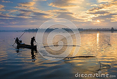 The silhouette of Fisherman throwing net in the early morning near U Bein Bridge, , Taungthaman Lake near Amarapura, Myanma Editorial Stock Photo