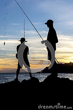 Silhouette of fishermen on the rocks of the Rio Vermelho beach in Salvador, Bahia, fishing for their food and support for their Editorial Stock Photo