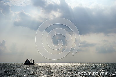 Silhouette of a fishing boat offshore Stock Photo