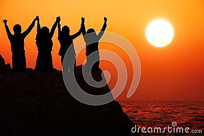 Silhouette four business people make high hands when business success ,teamwork concept. Stock Photo