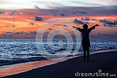 Silhouette of free woman enjoying freedom feeling happy at beach Stock Photo