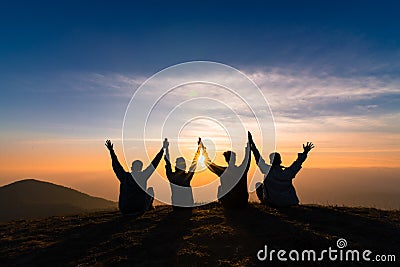 Silhouette of friends shake hands up and sitting together in sun Stock Photo