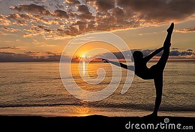 Silhouette of girl enjoying her morning dance exercise at a beach sunrise Stock Photo