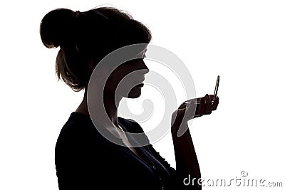 Silhouette of a girl with handpicked hair, profile of a woman face looking in a pocket mirror, the concept of the beauty and fashi Stock Photo