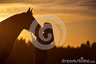 Silhouette of Girl Kissing Horse Stock Photo