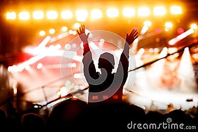 Silhouette of a girl with raised hands at a mass event. Party in a nightclub Editorial Stock Photo