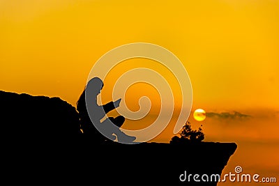 Silhouette,girl reading a book at sunset Stock Photo