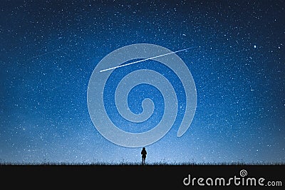 Silhouette of girl standing on mountain and night sky with shooting star. Alone concept Stock Photo