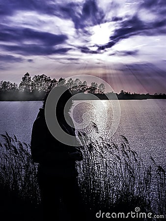 Silhouette of girl walking on the lakeside Stock Photo