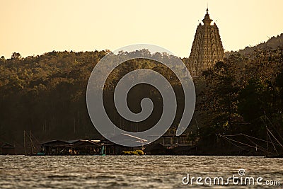 Silhouette golden chedi Buddhakhaya (mon) in the evening sunset sky with river and boat house at sangkhlaburi Stock Photo