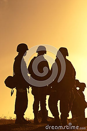 Soldiers standing against sunset Stock Photo