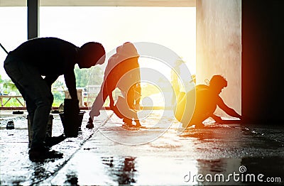 Silhouette group of workers build the cement floor in the house under construction Editorial Stock Photo