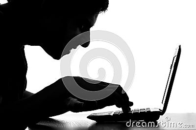 Silhouette of a hacker typing on the keyboard of laptop Stock Photo