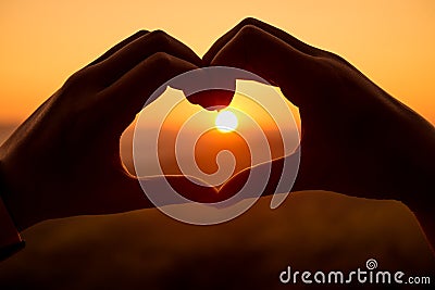 Silhouette hand in heart shape Stock Photo