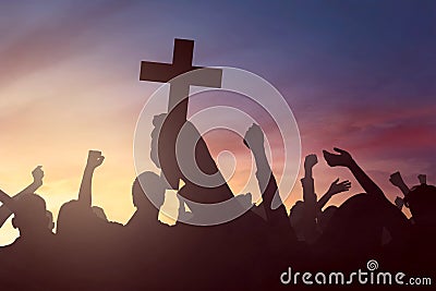 Silhouette hand holding christian cross Stock Photo
