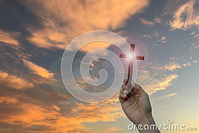 Silhouette hand holding wood cross against sunrise background, open palm up worship, pray for blessings from God. Christian Stock Photo