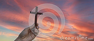 Silhouette hand holding wood cross against sunrise background, open palm up worship, pray for blessings from God. Christian Stock Photo