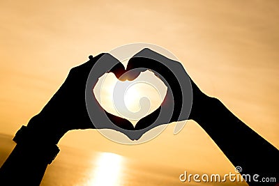 Silhouette hand making heart shape with sunset Stock Photo