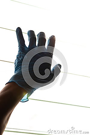 Silhouette Hand Wearing Blue Gloves With Light Louvers Stock Photo