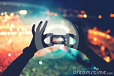 Silhouette of hands using camera phone to take pictures and videos at pop concert, festival Stock Photo