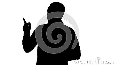 Silhouette Handsome young man walking and looking to the camera and pointing to the sides showing something. Stock Photo