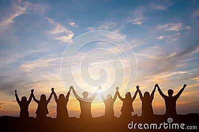 Silhouette of happy business team making high hands in sunset sk Stock Photo