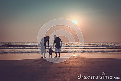 Silhouette of a happy family with children at sunset sea. Arambol beach, North Goa, India Stock Photo