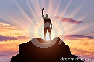 Silhouette of a happy mountaineer on top of a mountain Stock Photo