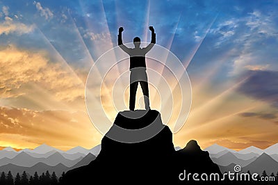 Silhouette of a happy mountaineer on top of a mountain. Stock Photo