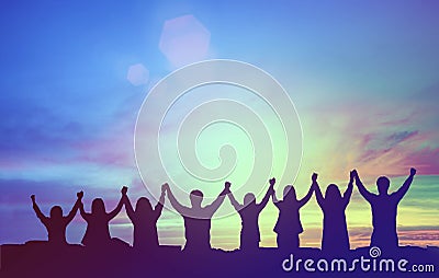 Silhouette of happy teamwork hold hands up as a business successful, victory. Business goal achievement, hit company target. Stock Photo