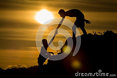 Silhouette of helping hand of a friend Stock Photo