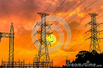 Silhouette high voltage electric pillars on sunset background Stock Photo