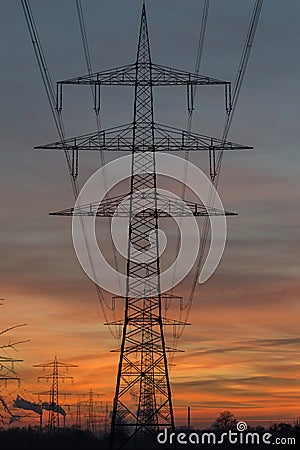 Silhouette of high voltage power lines against a sunset sky Stock Photo