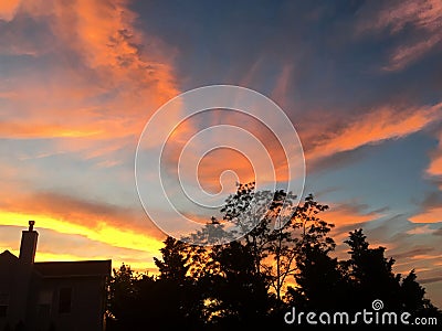 Silhouette of House and Tree Against Sunset Stock Photo
