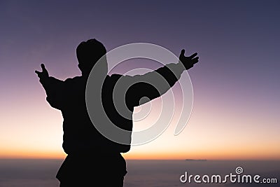 Silhouette of a human hand opens its palm to worship. the sun is rising concept of christianity Fight and win for God. Human Stock Photo