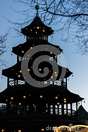 Silhouette of illuminated Chinese Tower in English Garden, Munich Stock Photo