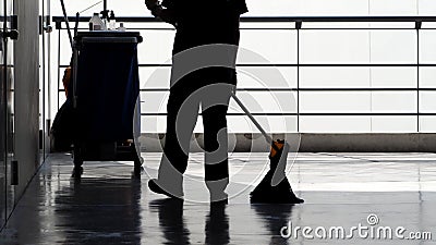 Silhouette of cleaning service people sweeping floor Stock Photo