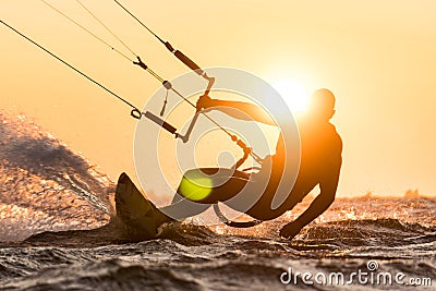 Silhouette of kitesurfer riding in sunset conditions with sun next to the riders head Editorial Stock Photo