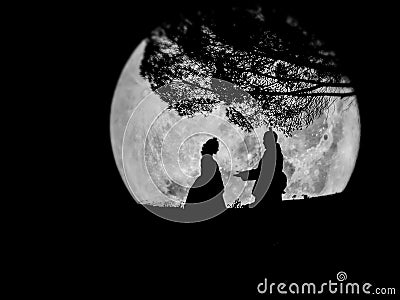 Silhouette Korean lover romance under big tree on full moon background Stock Photo