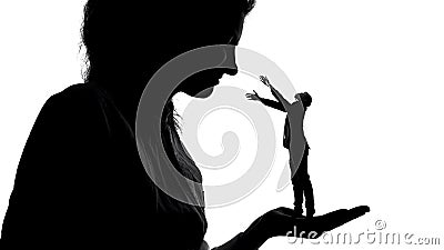 Silhouette of lady holding tiny male admirer in hand, women power, domination Stock Photo